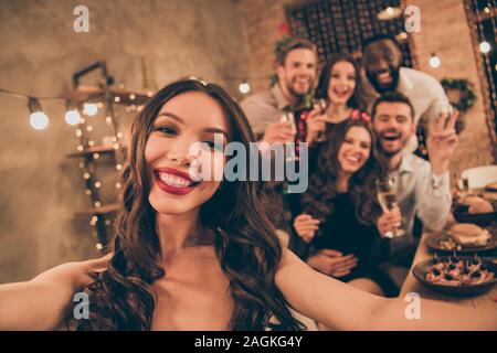 Close up foto di allegro amanti festeggiare il Natale Christmas party effettuare selfie si riuniscono intorno al tavolo con festa in casa piena di luci newyear in ambienti interni Foto Stock