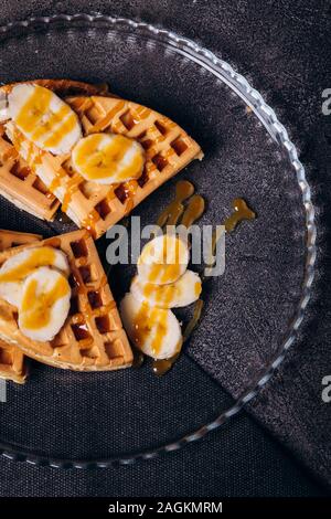 Le cialde con le banane in un concreto sfondo grigio. Foto Stock