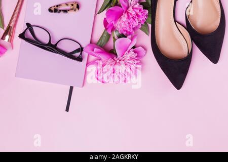 Composizione creativa con donna di accessori e di un bel colore rosa peonie Foto Stock