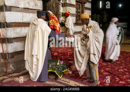 Etiopia, Amhara Region, Lalibela, Yemrehanna Kristos monastero, festival dell'Arcangelo Gabriele, pellegrini al di fuori grotta chiesa di donazione al sacerdote Foto Stock