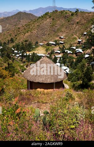 Etiopia, Amhara Region, Lalibela, Bilbala, circolare tradizionale casa di paglia in corrispondenza del bordo del nuovo sviluppo di lamiera case dal tetto Foto Stock