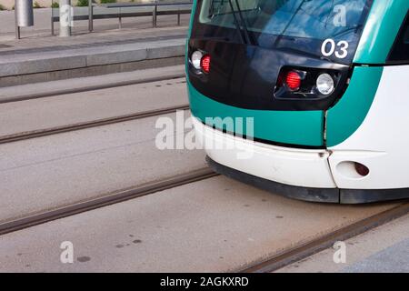 Close-up di un moderno di colore verde e bianco con il tram in rotaie. Dettaglio delle luci, un numero tre e la cabina di guida del tram ferma in tramwa Foto Stock