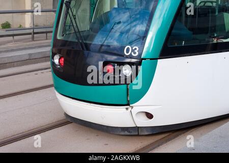 Close-up di un moderno di colore verde e bianco con il tram in rotaie. Dettaglio delle luci, un numero tre e la cabina di guida del tram ferma in tramwa Foto Stock