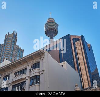 Guardando verso il cielo da una strada nel quartiere finanziario centrale di Sydney con la Torre di Sydney che si erge sopra gli edifici che la circondano Foto Stock