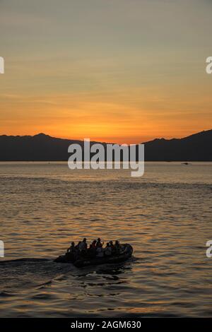 I passeggeri da L'Austral nave da crociera in zodiac al tramonto sulla spiaggia rosa, Mare Flores, Indonesia Foto Stock