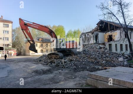 Digger demolizione di case per la ricostruzione Foto Stock