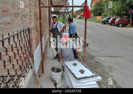Di Zrenjanin, Serbia, giu 29, 2013. Styrofoam adesivo alla parete di facciata i lavoratori. Costruzione di isolamento consente di risparmiare energia. Foto Stock