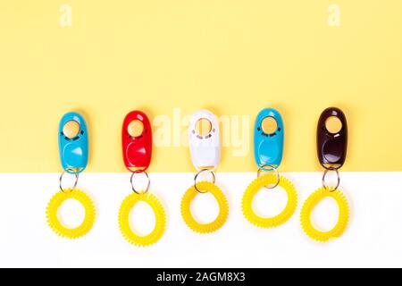 Alcuni clickers colorati per il traning cane con un rinforzo positivo. Lay piatto. Posto per il testo. Foto Stock