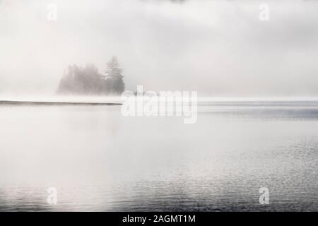 Fredda mattina nebbia oltre il bellissimo lago in autunno Foto Stock