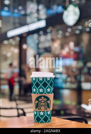 Mosca, Russia - 10 dicembre 2019: Starbucks Cafe interior in Columbus mall, il bicchiere di carta con logo in primo piano Foto Stock