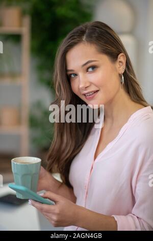 Bella giovane donna la digitazione di un messaggio sul telefono Foto Stock