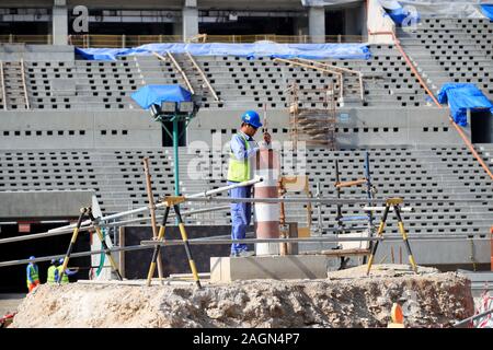 Un lavoratore edile opere dove il centro posto sarà a Lusail Stadium di Lusail, in Qatar. Foto Stock