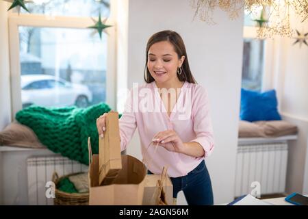 Bella donna positiva messa in regalo la borsa Foto Stock