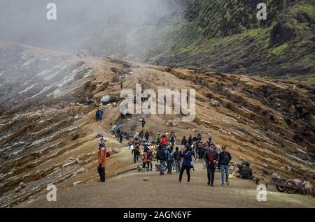 I turisti sul bordo del cratere del Monte Ijen, Banyuwangi, East Java, Indonesia Foto Stock
