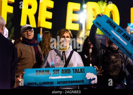 Barcellona, Spagna - 18 dicembre 2019: sorridente donna catalana cerca azienda spagna sedersi e parlare di banner durante la protesta per l'indipendenza catalana durante e Foto Stock