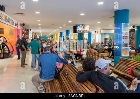 Belize City, il Belize - Novembre, 18, 2019. I passeggeri in attesa per i loro voli internazionali all'interno Philip S W Goldson Aeroporto. Foto Stock