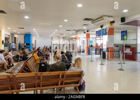 Belize City, il Belize - Novembre, 18, 2019. I passeggeri in attesa per i loro voli internazionali all'interno Philip S W Goldson Aeroporto. Foto Stock