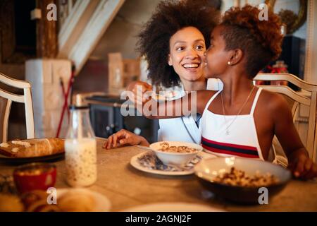 Sorridente madre e figlia insieme per la prima colazione alla mattina di Natale Foto Stock