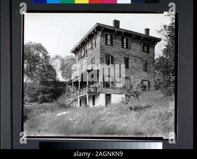 Tre piani telaio in legno casa con parzialmente visibile nel seminterrato, fasi che portano fino alla veranda in legno sulla parte anteriore, staffe decorative lungo il tetto Citazione/Riferimento: CNY# 13 Codice: I.A.2.; palizzata Avenue n. 2505, Spuyten Duyvil, Bronx. Foto Stock