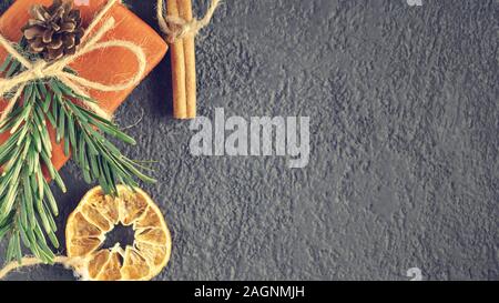 Natale o Capodanno sfondo con decorazioni da materiali naturali - albero di Natale ramoscelli, cannella e arancio essiccato Foto Stock