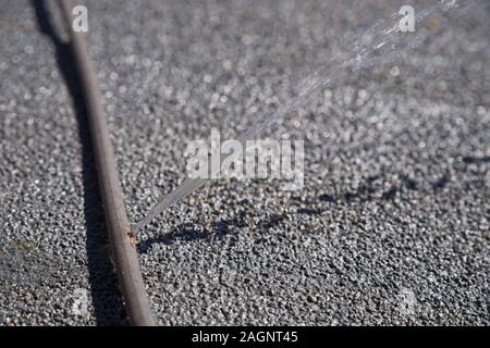 Il tubo in rame che dividono da congelamento spruzzare acqua su un tetto Foto Stock