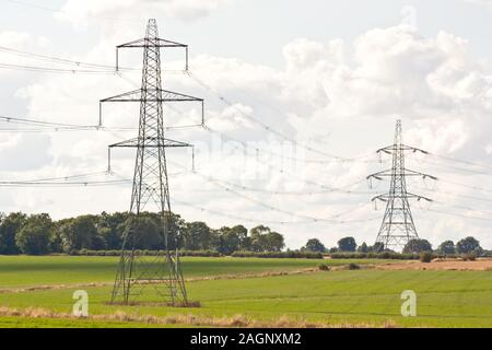 Una fila di piloni di elettricità si dipanano attraverso la campagna nel Regno Unito. Foto Stock