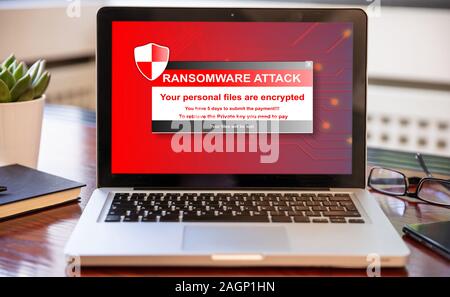 Testo Ransomware sullo schermo del computer, cyber attacco concetto. Office business scrivania di legno dello sfondo. Foto Stock