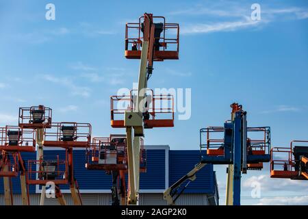 Un industria di costruzione di unità di memorizzazione e di cantiere è visto con un gruppo di elevazione mobile di piattaforme di lavoro, MEWP o raccoglitori di ciliegio, a riposo e memorizzati Foto Stock