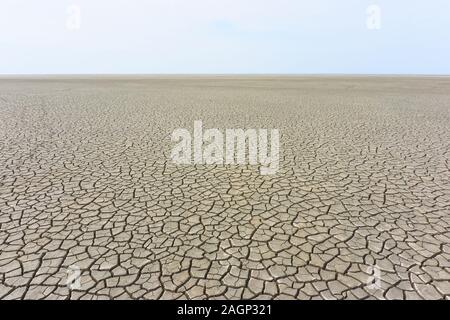 Paesaggio desolato con massa fessurato in riva al mare. Marrone, beige, marrone chiaro e grigio colorato. Concetto di riscaldamento globale. Foto Stock