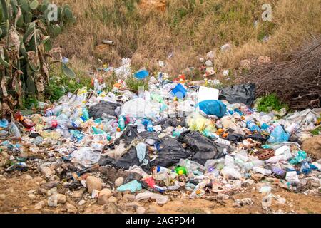 Un enorme carico di spazzatura pieno di plastica, carta, metallo oggetto di dumping nella campagna di Sicilia, Italia. Foto Stock