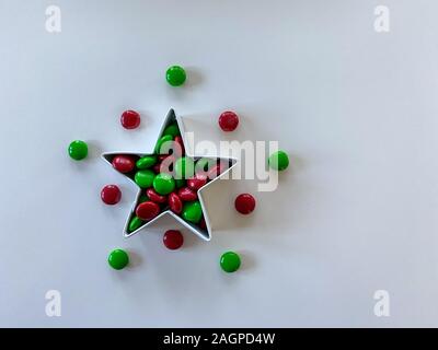 Orlando,FL/USA-12/20/19: Stella formina riempito con gustosi piatti di colore rosso e verde M&M tipo pulsante cioccolato candy tratta su una tavola di legno. Foto Stock