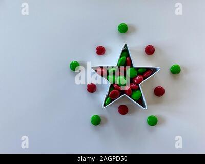 Orlando,FL/USA-12/20/19: Stella formina riempito con gustosi piatti di colore rosso e verde M&M tipo pulsante cioccolato candy tratta su una tavola di legno. Foto Stock