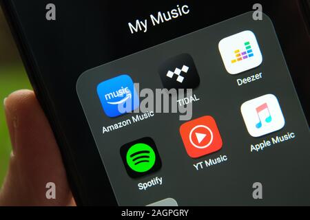 La riproduzione in streaming di musica le app sulla schermata dello smartphone tenere in mano. Concetto di concorrenza. Close up foto. Foto Stock