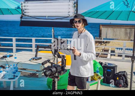 Steadicam operatore e il suo assistente Preparazione della fotocamera e 3-asse-stabilizzatore di sospensione cardanica per un commerciale shoot Foto Stock