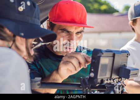 Steadicam operatore e il suo assistente Preparazione della fotocamera e 3-asse-stabilizzatore di sospensione cardanica per un commerciale shoot Foto Stock