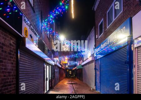 Le luci di Natale a zig zag lungo Union Street in lettura, Regno Unito visto qui di notte. I negozi sono chiusi con ante in basso. Foto Stock