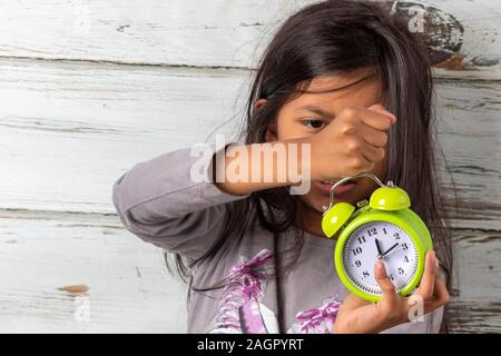 Bambina svegliarsi con una sveglia Foto Stock