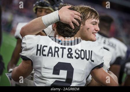 Arlington, TX, Stati Uniti d'America. Xx Dec, 2019. Texarkana piacevole Grove Hawks running back Bruce Garrett (2) abbraccia un compagno di squadra durante gli ultimi secondi del Texas University Interscholastic League (UIL) classe 4A DIVISIONE 2 stato campionato di gioco tra il piacevole Texarkana Grove e i falchi della Wimberley Texans di AT&T Stadium di Arlington, TX. Texarkana piacevole Grove sconfitto Wimberley 35-21. Prentice C. James/CSM/Alamy Live News Foto Stock