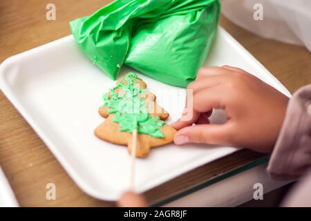 I bambini facendo tradizionali decorazioni di Natale con fatto a mano i cookie Foto Stock