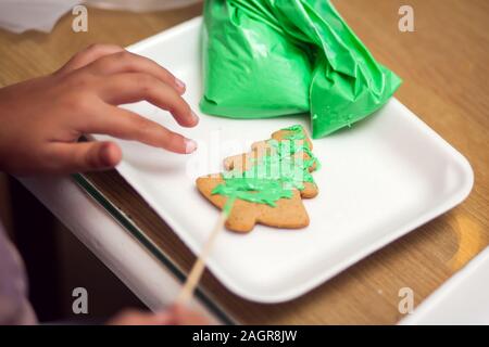 I bambini facendo tradizionali decorazioni di Natale con fatto a mano i cookie Foto Stock