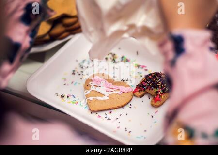 I bambini facendo tradizionali decorazioni di Natale con fatto a mano i cookie Foto Stock