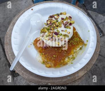 Arabo Kunafa dessert fatto con formaggio e miele e pistache con gelato Foto Stock