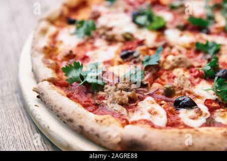 Pizza con carne e puttanesca, close-up, tonica immagine Foto Stock