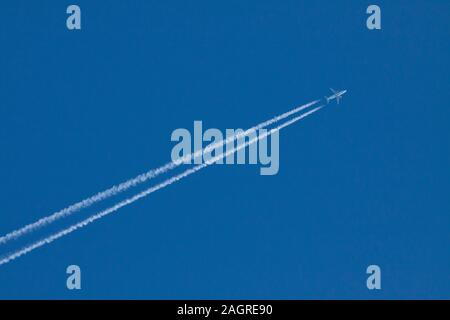 Piano di jet con contrails sul cielo azzurro sfondo Inghilterra Bedfordshire Regno Unito Foto Stock