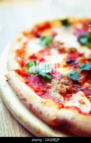 Pizza con carne e puttanesca close-up, tonica immagine Foto Stock