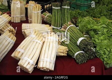 Molti grappoli di bianco e asparago verde in un mercato in stallo Foto Stock