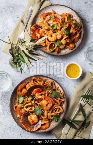 Spaghetti di mare con conchiglie, gamberi, calamari su sfondo grigio. Mediterranea italiana il concetto di cibo Foto Stock