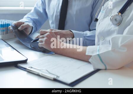 Stretta di mano del paziente e medico consultazione la prescrizione di trattamento. Compatibile con i raggi x e test medici. Foto Stock