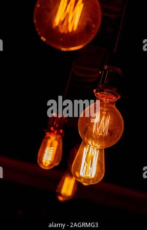 Moderno e in stile vintage le lampadine della luce in un buio public house Foto Stock