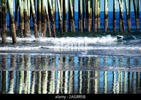 I supporti in legno della Old Orchard Beach pier sempre colpito da onde nel Maine su una soleggiata giornata invernale. Foto Stock